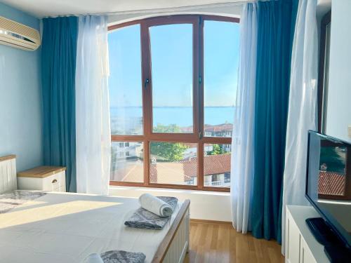 a bedroom with a large window with a view of the ocean at Triumph Fantastic View in Sveti Vlas