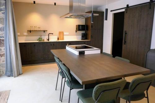 a kitchen with a wooden table and chairs at Grange rénovée - Calme et Vue sur les volcans in Saint-Just-près-Brioude