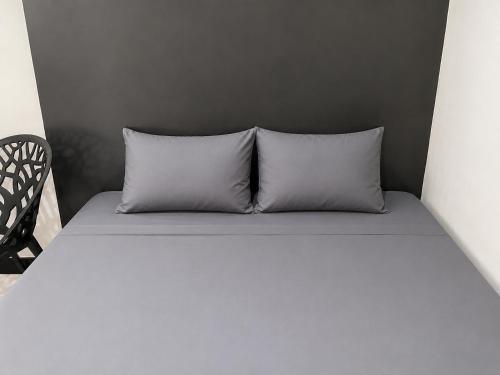 two pillows sitting on a bed in a room at NamRoom at Kalimalang in Cibening