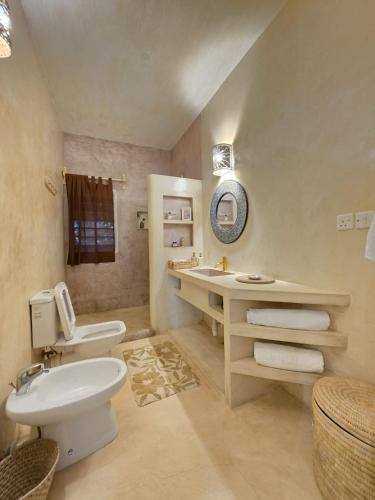 a bathroom with a white toilet and a sink at Ocean zuri villa in Watamu
