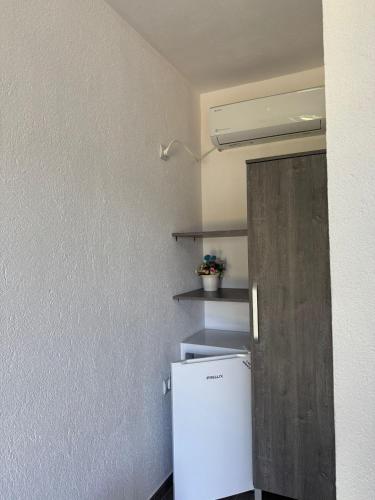 a small kitchen with a white refrigerator and shelves at Casa Osan in Tăşnad