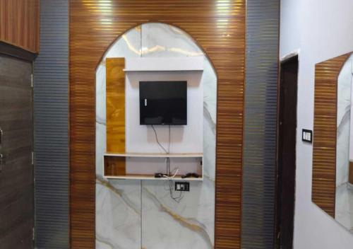 a bathroom with a tv on a wall at Shree ji Hotel and Resort in Ujjain