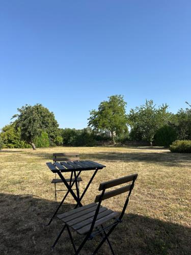 a picnic table and a bench in a field at Chambre d'hôtes bed and breakfast in La Chapelle-Faucher