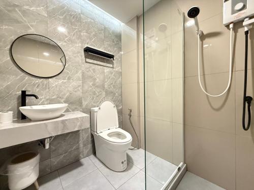 a bathroom with a toilet and a sink and a shower at Kelly Hotel Bangsean in Ban Laem Thaen