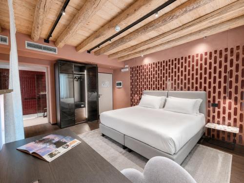 a bedroom with a large white bed and a table at Hotel Doriguzzi in Feltre