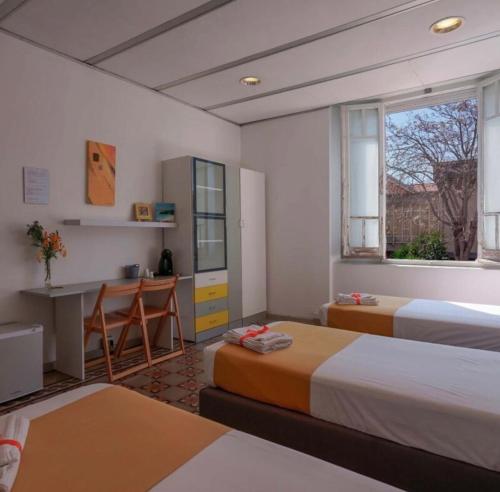 a hotel room with two beds and a desk at Lungomare Casa Diaz in Cagliari