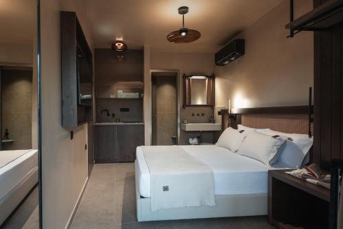a bedroom with a large white bed and a bathroom at Pournari Center Toroni in Toroni