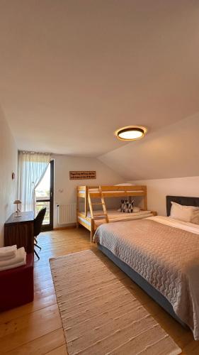 a bedroom with a bed and a desk and a table at Family Nest Băișoara - Confort Premium, Wi-Fi rapid, ciubăr la cerere și view spectaculos in Muntele Băişorii