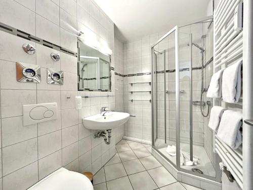 a white bathroom with a shower and a sink at Rubiblick, Montana Haus in Oberstdorf