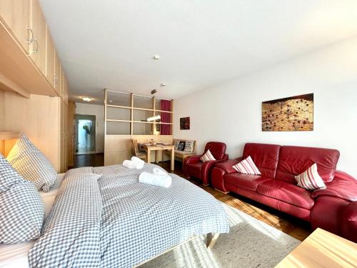 a living room with a red couch and a red bed at Rubiblick, Montana Haus in Oberstdorf