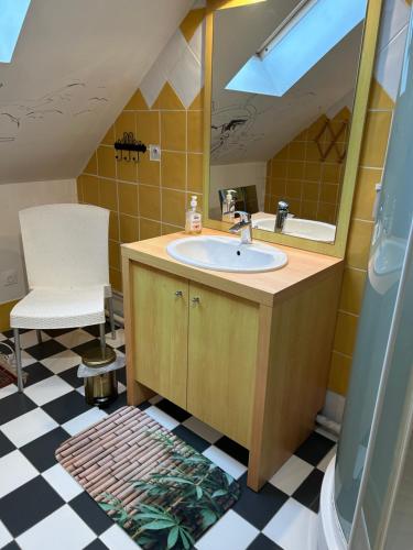a bathroom with a sink and a mirror and a chair at Villa grain de sel in Étaples