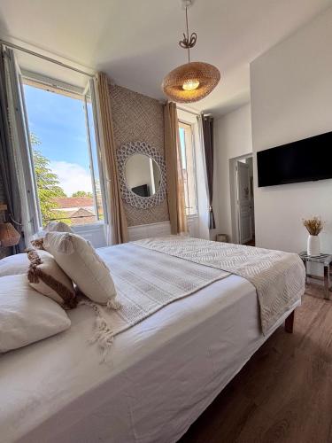 a bedroom with a large white bed with a large window at Les Chambres Salonaises in Salon-de-Provence