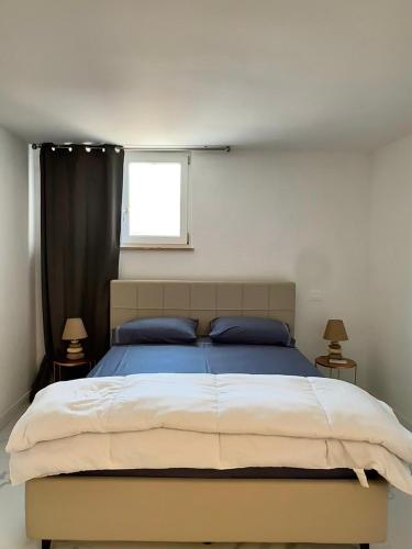 a bedroom with a bed with blue pillows and a window at Villa Olimpia in Civitavecchia