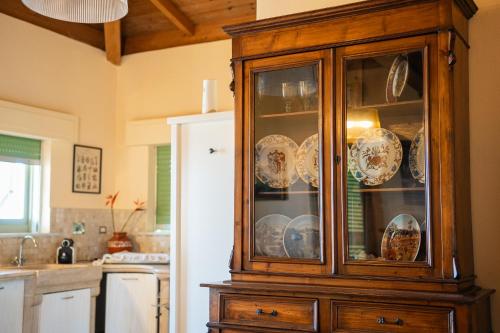 a wooden cabinet with dishes in it in a kitchen at Casamare Hotel in San Vincenzo