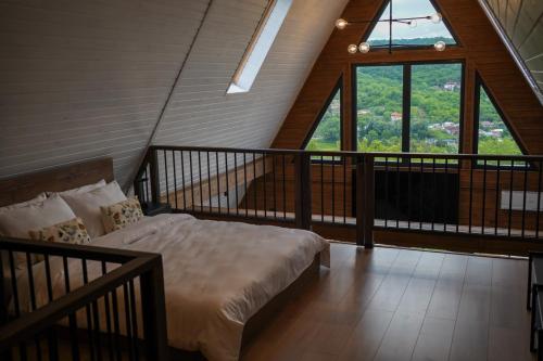 a bedroom with a bed on a balcony with windows at Colina Monteoru in Sărata-Monteoru