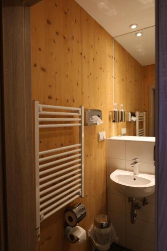a bathroom with a sink and a toilet and a mirror at URBAN OAK Smart Stay in Cologne