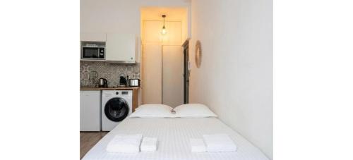 a small room with a bed and a washer and dryer at Doux Pavillon - La Palmeraie in Nice
