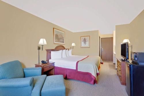 een hotelkamer met een bed en een televisie bij Pinedale Hotel & Suites in Pinedale