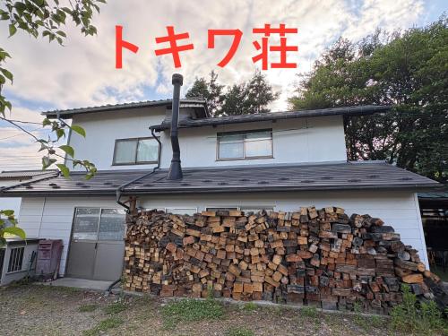 a pile of fire wood in front of a house at 一棟貸しの宿 餓鬼大将と別館トキワ荘 in Omachi