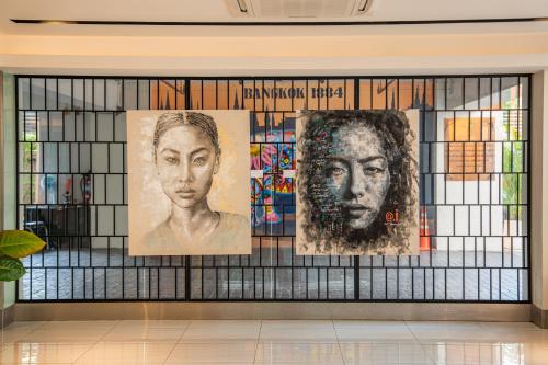 a wall with portraits on it in a building at The Mandison Bangkok - Formerly Golden Tulip Mandison Suites in Bangkok