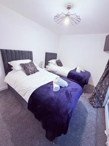 a bedroom with two beds and a chandelier at Anex Highfield Guest House in Idle