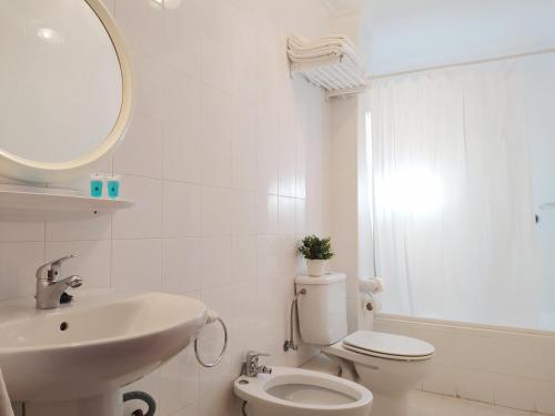 a bathroom with a sink and a toilet and a mirror at Apartamentos Pagán Alejandro in San Javier