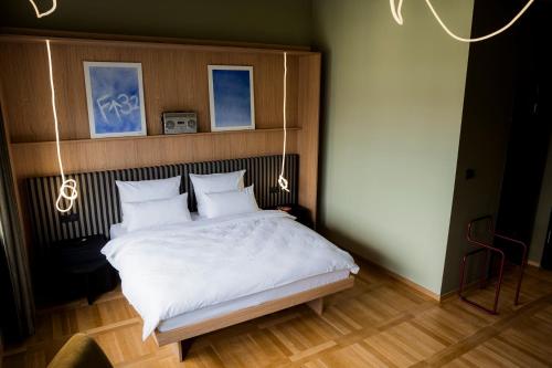 a bedroom with a large bed with white sheets at ALPAMI Boutique Glockenbach in Munich
