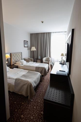 a hotel room with two beds and a television at Aviator Hotel in Radom