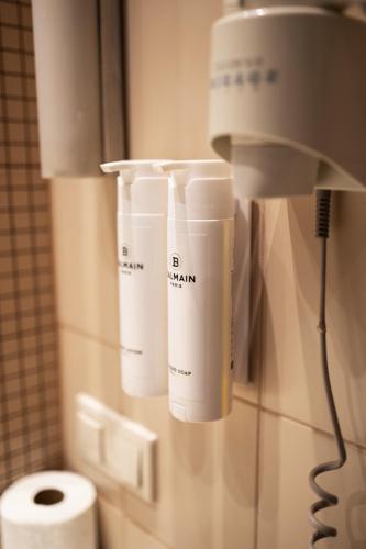 a bathroom with a toilet and two cups on the wall at Aviator Hotel in Radom