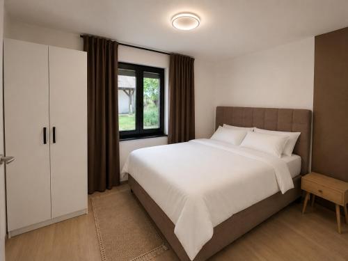 a bedroom with a large bed and a window at Ranč Zlatne niti by Acin salaš in Tordinci