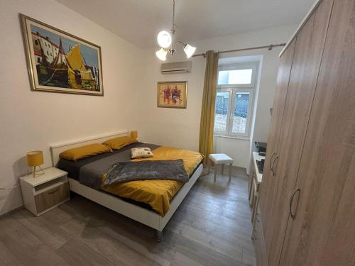 a bedroom with a bed and a desk and a window at Rooms Marija in Malinska