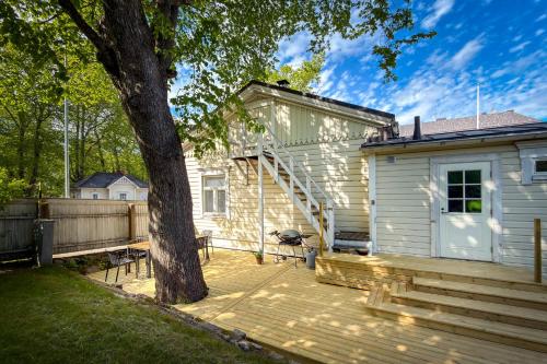 a house with a wooden deck next to a tree at Hanko Sailor House in Hanko