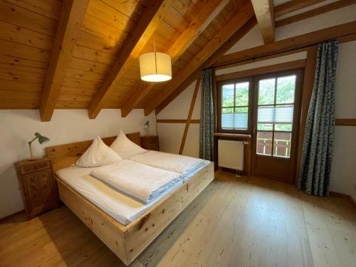 a bedroom with a bed in a wooden house at Haus Bergheimat in Obermaiselstein
