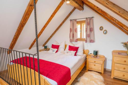 a bedroom with a bed with a red blanket at Haus Sunnseit'n in Pöllauberg