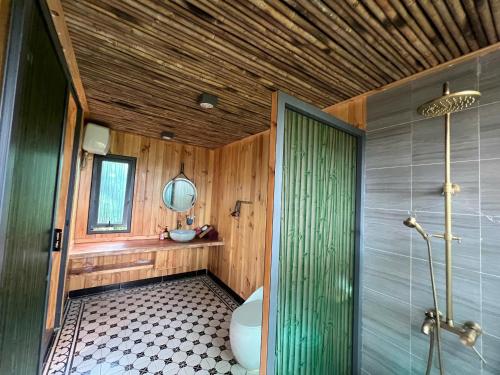 a bathroom with a shower and a toilet and a sink at Rao Retreat in Ấp Xuân Khai