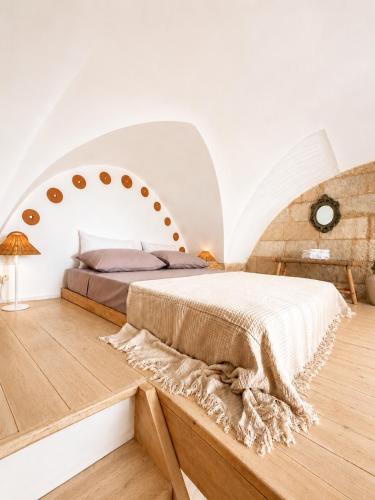 a bedroom with a large bed in an attic at Pètra Boutique Home by Symphonya Luxury Holiday Rentals in Scorrano