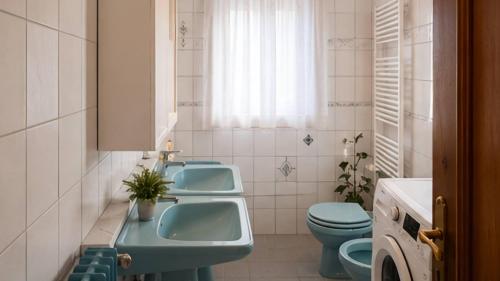 a bathroom with two sinks and a toilet at Appartamento Graziella in Castello di Fiemme