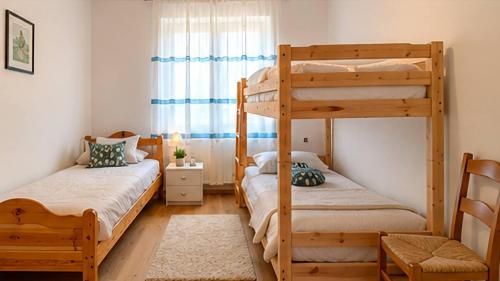 a bedroom with two bunk beds and a window at Appartamento Graziella in Castello di Fiemme
