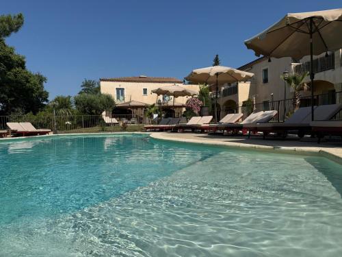 a swimming pool with chairs and umbrellas at CÉRÈS - Boutique-Hôtel & Spa - Élégance en Terre d'Uzès in Saint-Quentin-la-Poterie