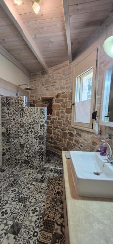 a bathroom with a sink and a stone wall at Villa Efthalia in Pitsidia