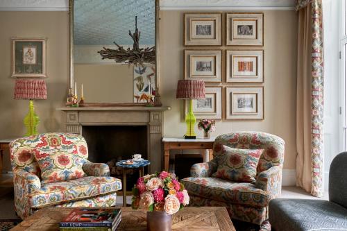 a living room with two chairs and a fireplace at Number Sixteen, Firmdale Hotels in London