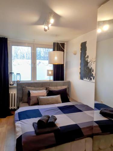 a bedroom with a large bed with a blue and white blanket at Studio park Katowice/Chorzów in Chorzów