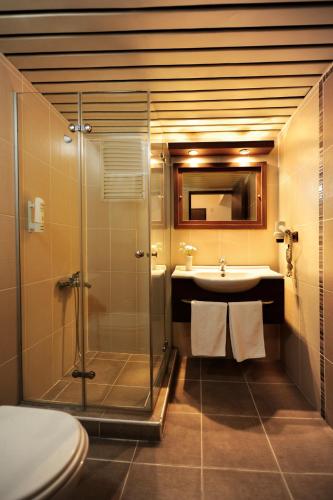 a bathroom with a shower and a sink at Üstün Hotel Alsancak in İzmir