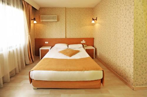 a bedroom with a large bed and two night stands at Üstün Hotel Alsancak in İzmir