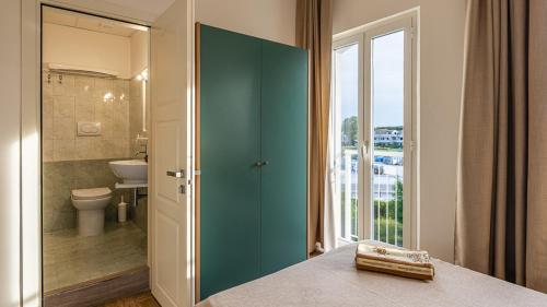 a bathroom with a green door and a toilet at Baby Gigli in Numana
