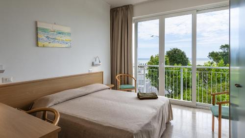 a bedroom with a bed and a large window at Baby Gigli in Numana