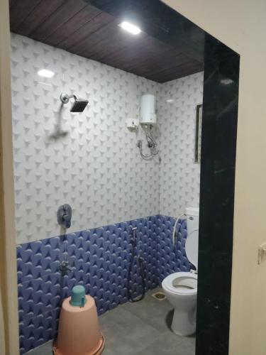 a bathroom with a toilet and a blue wall at Hotel Garden View - Andheri West in Mumbai