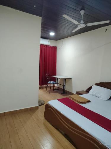 a bedroom with a bed and a table in it at Hotel Garden View - Andheri West in Mumbai