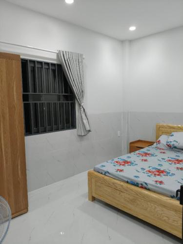 a bedroom with a bed and a window at Phú Hưng Gia Motel in Ðức Hòa