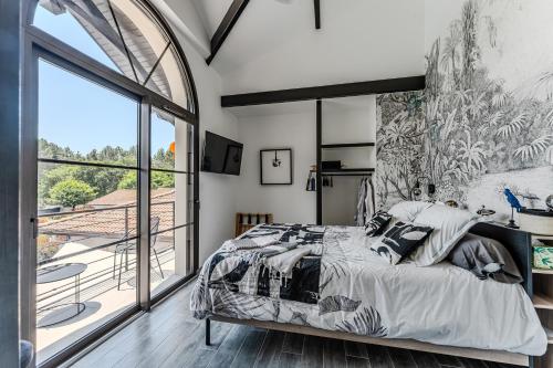 a bedroom with a bed and a large window at Tomland in Parentis-en-Born
